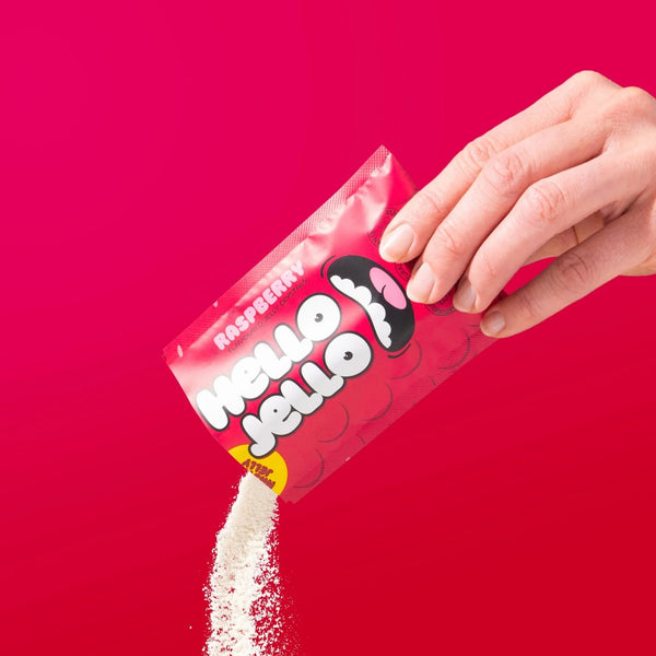 Pouring HELLO JELLO Raspberry jelly crystals from the sachet