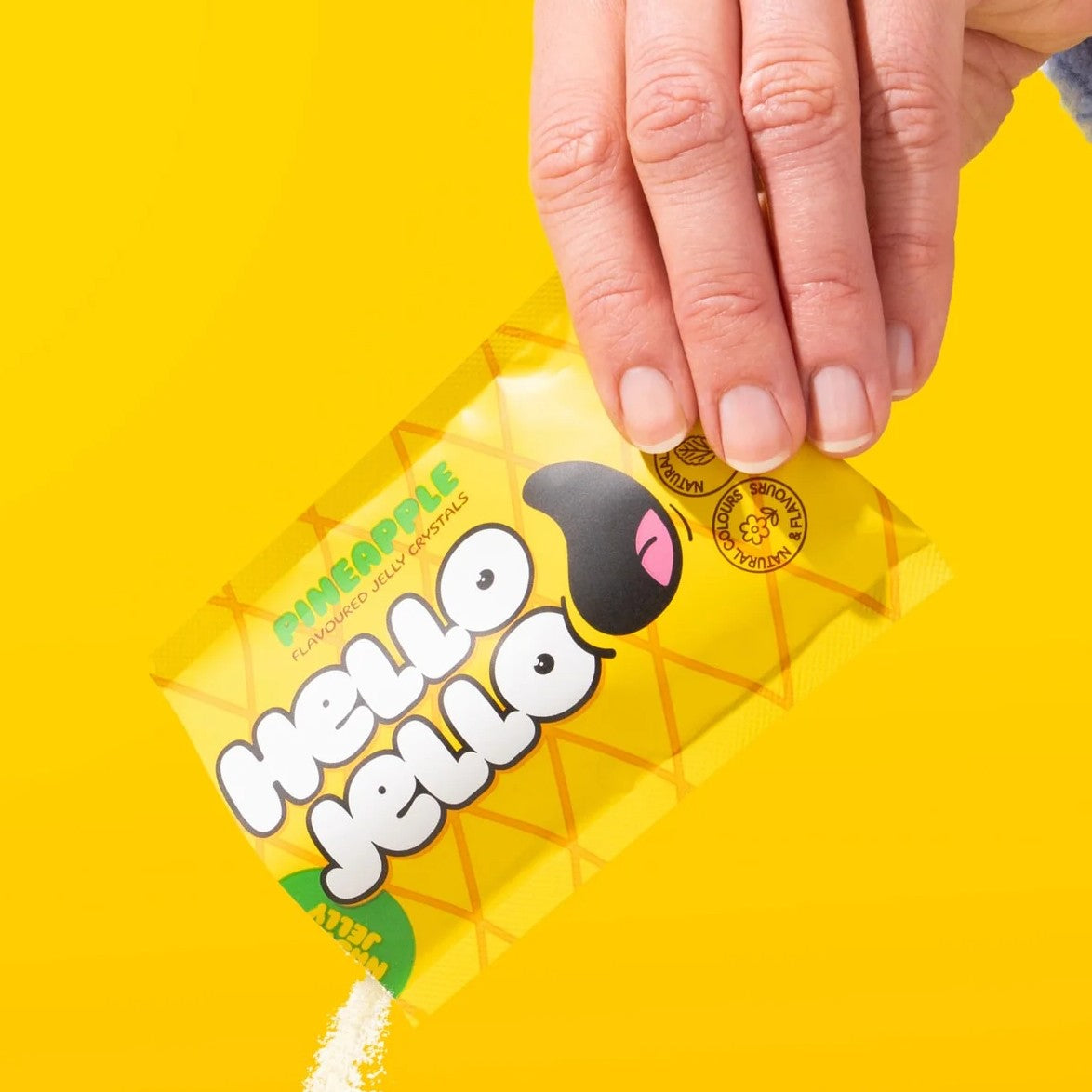 Pouring HELLO JELLO Pineapple jelly crystals from the sachet